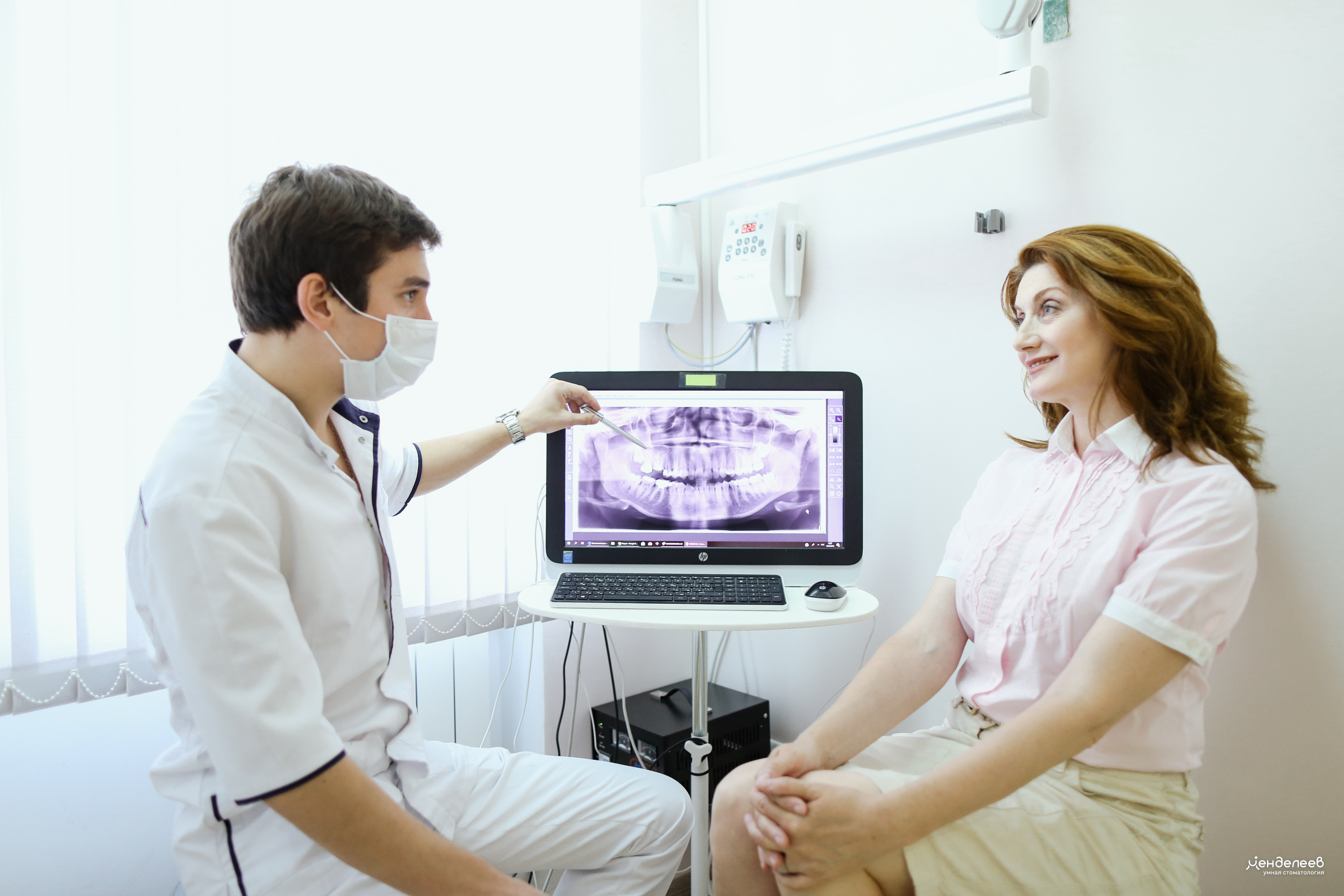 стоматолог обсуждает с пациентом рентгеновский снимок